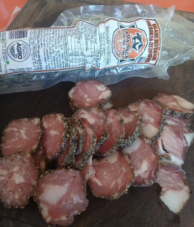 Salame defumado com borda de pimenta Lá da Roça, cortado em rodelas